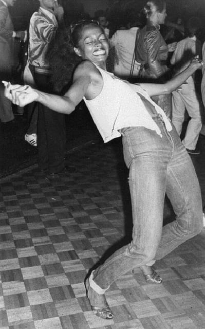 An adult women dancing and expressing joy on a dancefloor, symbolizing true happiness from dancing.