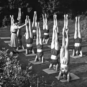 Vintage scene of a group performing handstands in a park, humorously overseen by an older lady in a dress, highlighting the fun and community spirit of Sweat Jam and Step Up fitness classes at The Vibe Dance Studio.