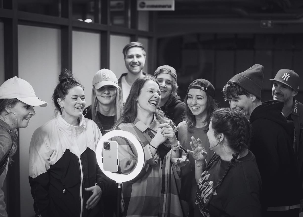 Laughing dancers looking at each other while collaboratively working on a dance project, embodying The Vibe Dance Studio's mission to share joy and build connections through movement.